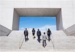 Business people ascending modern stairs