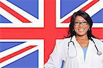 Portrait of confident mixed race female surgeon over British flag