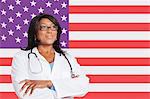 Confident mixed race female surgeon looking away over American flag