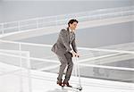 Businessman riding scooter down walkway