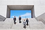 Business people descending urban stairs