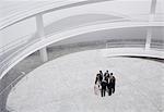 Business people standing in circle of modern courtyard