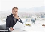 Businessman with lunch reviewing paperwork