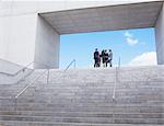 Business people meeting at top of urban stairs