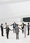 Business people holding hands in circle