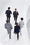 Business people ascending elevated walkway