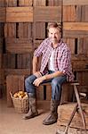 Portrait of smiling man sitting next to bushel of apples