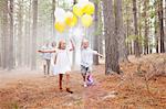 Happy family with balloons in woods