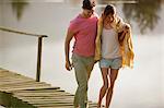 Couple walking on dock over lake