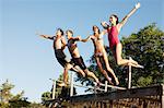 Friends jumping off dock