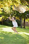 Happy girl running with butterfly net in grass