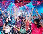 Confetti falling over enthusiastic crowd on dance floor of nightclub