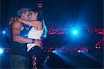 Smiling couple hugging under spotlights in nightclub