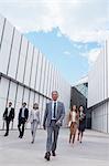 Confident business people walking outside building