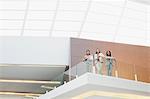 Portrait of smiling businesswomen standing on balcony in modern office