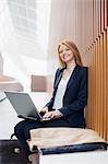 Portrait of smiling businesswoman using laptop