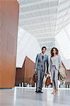 Portrait of smiling businessman and businesswoman in modern lobby