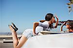 Smiling women high-fiving in convertible