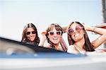 Smiling women driving convertible