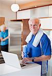 Older man using laptop after workout