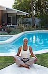 Older woman meditating in backyard