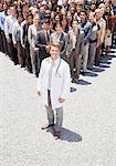 Portrait of confident doctor with business people in background