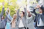 Crowd of business people cheering with arms raised