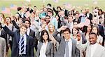 Portrait of smiling business people waving American flags overhead