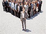 Portrait of confident businesswoman with team of business people in background