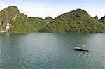 A man in a fishing boat, Ha Long Bay, UNESCO World Heritage Site, Vietnam, Indochina, Southeast Asia, Asia