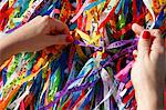 Woman tying lucky ribbon at Igreja Nosso Senhor do Bonfim church, Salvador (Salvador de Bahia), Bahia, Brazil, South America