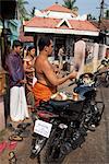 Priest blessing a new motorcycle outside a temple in Kochi (Cochin), Kerala, India, Asia