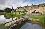 Stone footbridge and cottages at Lower Slaughter in the Cotswolds, Gloucestershire, England, United Kingdom, Europe