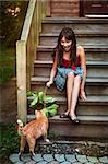 Girl in red dress playing with cat