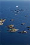 Large cruising ship passing by tiny islands on norwegian coast near town of Henningsvaer on Lofoten islands