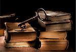 Conceptual still life image of old antique books and a big old key.