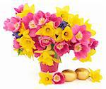 Tulip, daffodil and hyacinth flower arrangement in a pink vase with gold easter chocolate egg group over white background.