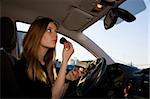 Young pretty woman preparing her make-up in car