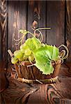 Grapes in a basket on a wooden background