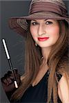 portrait of a beautiful woman in black dress, brown hat and mouthpiece with cigarette