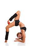 Flexible fitness woman  holding an apple against the thigh with the other's foot toes while doing back arch on elbows over white background.