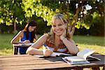 People and education, two young women studying with book for university test in park and smiling at camera