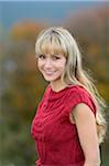 Portrait of Woman with Blond Hair Wearing Red Sleeveless Sweater Outdoors in Autumn