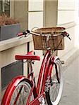 Close-up of red, classic, road bicycle with wicker basket attached to handlebars, Paris, France