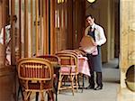 Portrait of Waiter Holding Tray at Charming Outdoor Cafe, Fontaine de Mars, Paris, France