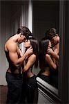 Couple hugging by mirror