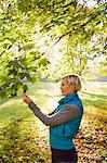 Woman admiring leaves in park