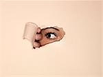 Woman peeking through hole in wall