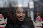 Woman wearing mittens at window