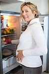 Pregnant woman standing at fridge